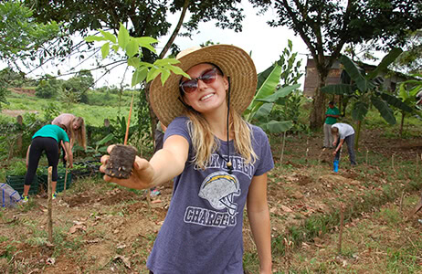 Student holding a tree sapling