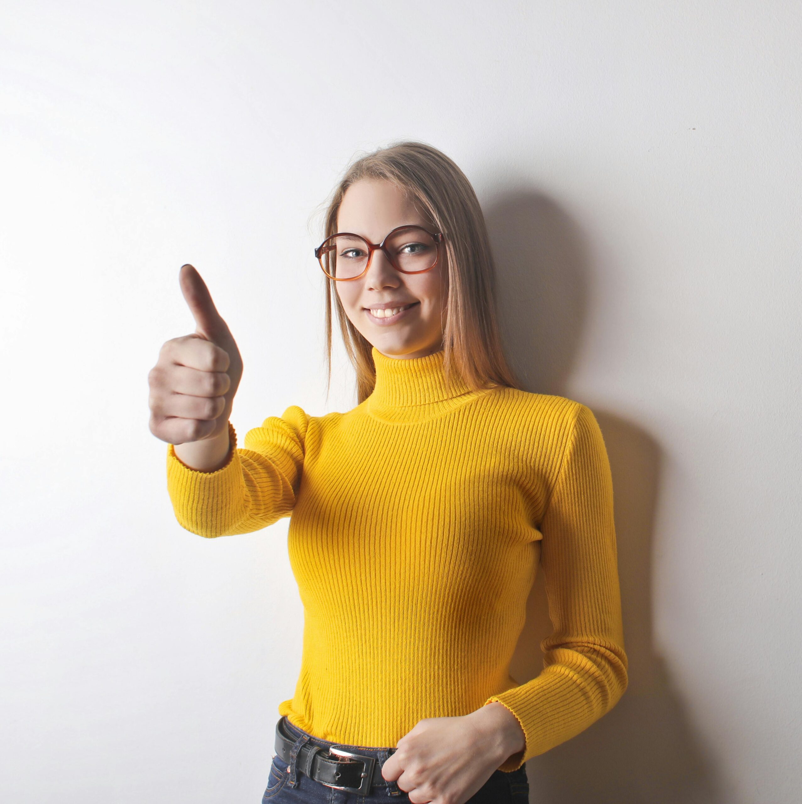 Person in a bright yellow sweater giving a thumbs-up gesture to represent positivity and confidence for ADHD Clinical Mastery CPD education