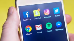 Hand Holding Smartphone With Social Media App Icons