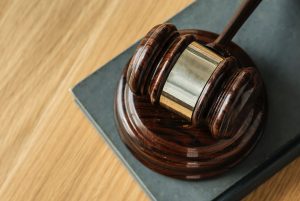 Wooden Gavel Resting On A Sounding Block And Law Book