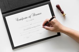 Hand Signing A Certificate Of Divorce Document With A Pen