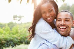 Smiling Couple Hugging Outdoors In Sunlight