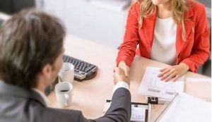 Professional Handshake Between Man And Woman Across Office Desk