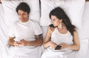 Suspicious Woman Peeking At Man'S Phone In Bed