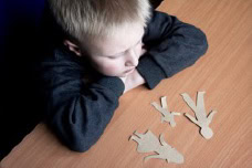 Young Boy Looking At Family Paper Cutouts