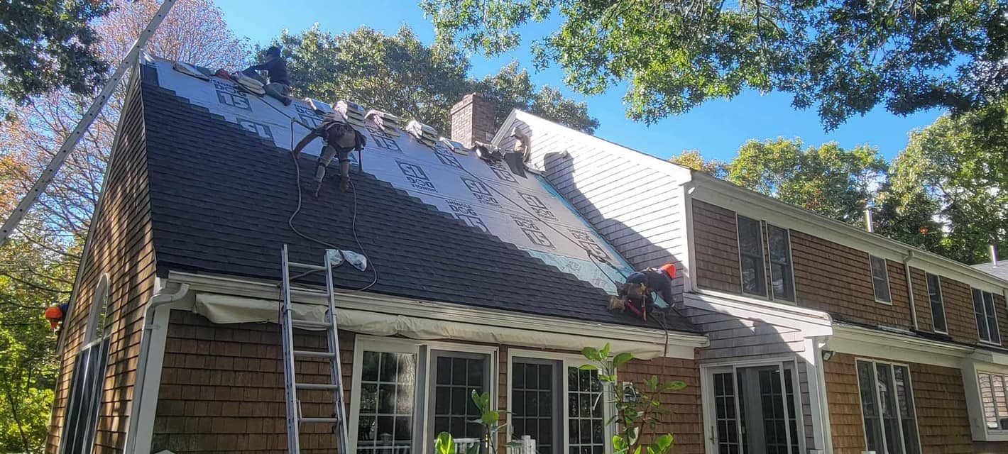 AMP Roofing crew installing GAF shingles on a Cape Cod style home in Easton