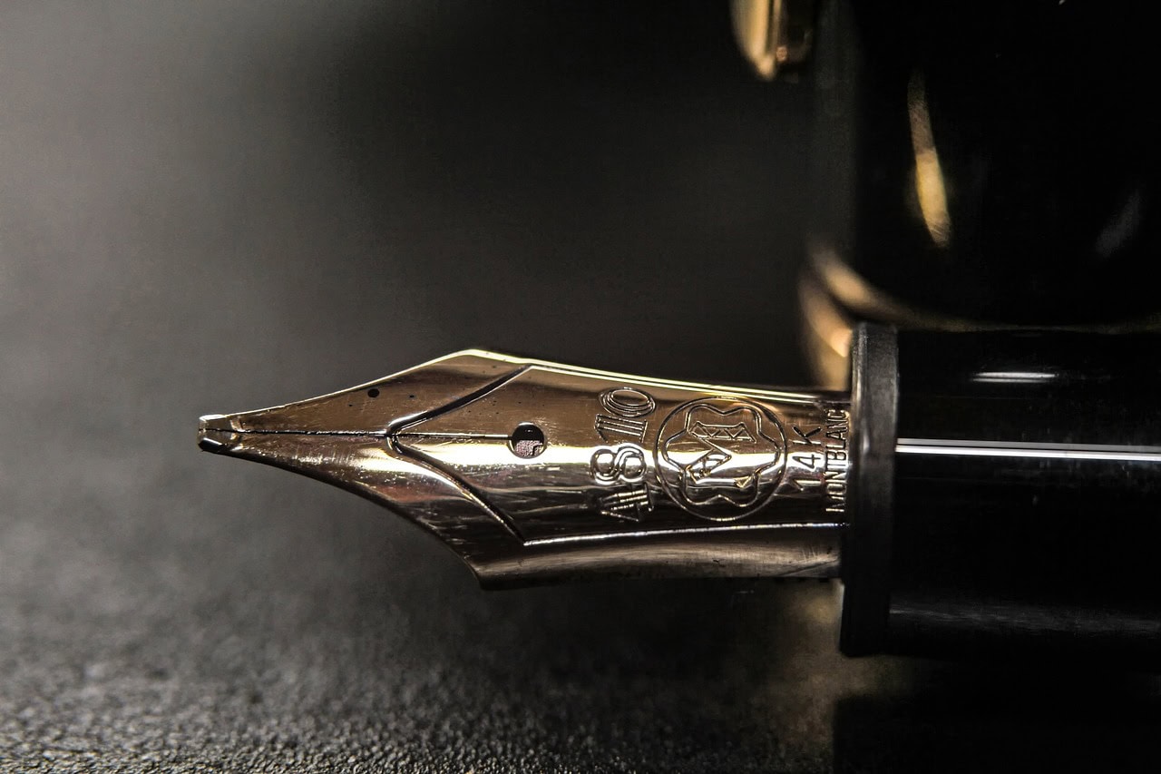 Photo montrant un stylo sur fond noir d'une plume Montblanc gravée "A810 14K Montblanc"