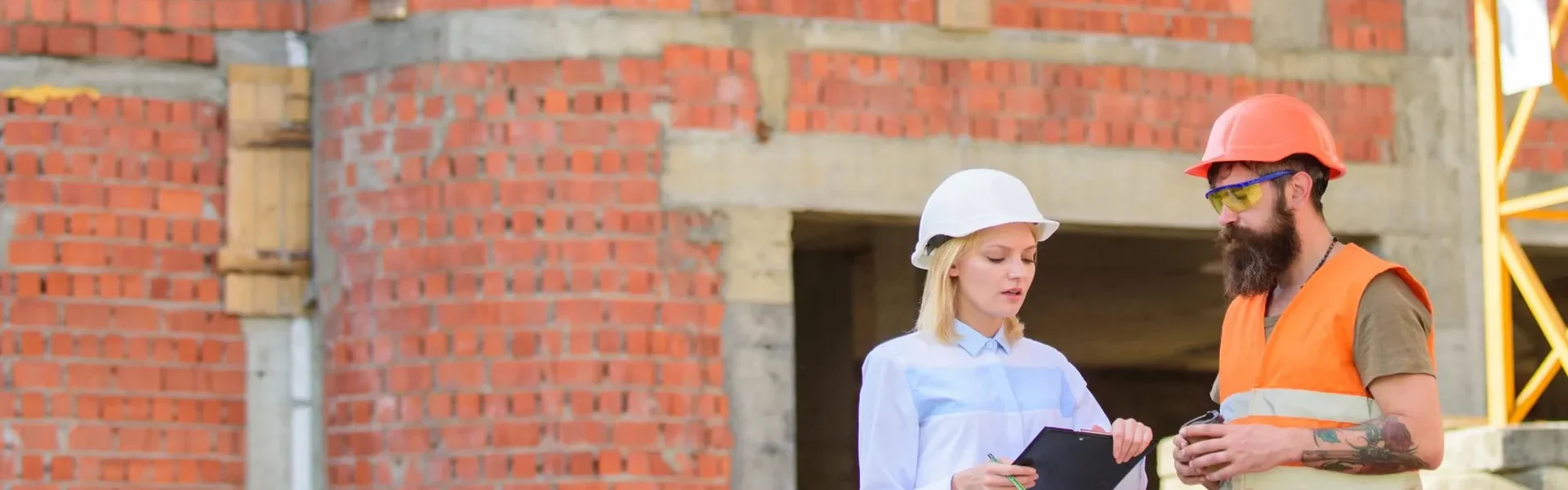 Dos personas hablando frente a una obra