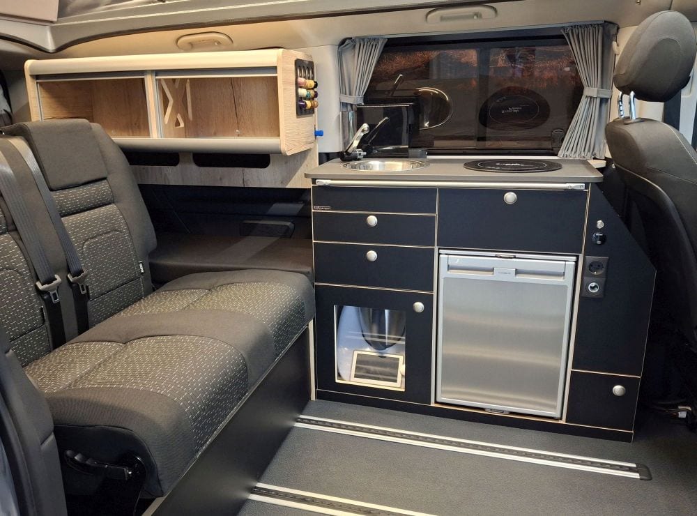 Hänge- Schiebeschrank verschiebbarer Hängeschrank optimiert kompakten Camper Grundriss NightSlider offen hinten Sitz