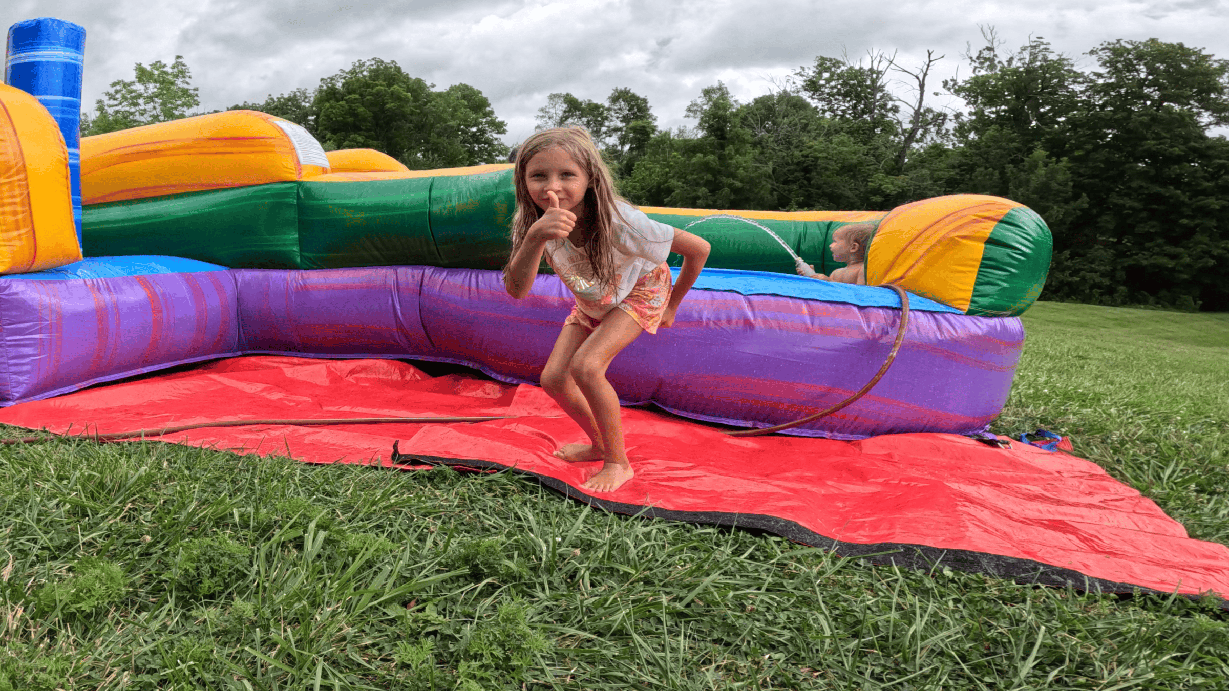 Girl giving thumbs up on Castle Clash bounce house — Backyard Responders