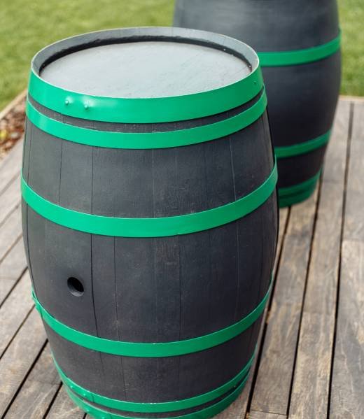 Photo of two black and green wine barrels outdoors
