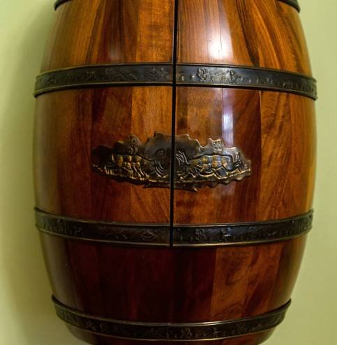 View of renovated old wooden brown barrel. Photo made in a museum. Barrel is covered with polish