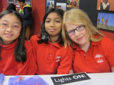 3 girls smiling in a Montessori classroom | Bishop Hamilton Montessori School in Ottawa