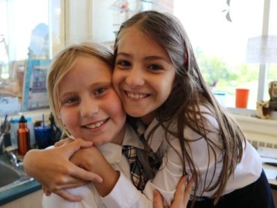 2 girls smiling in a Montessori classroom | Bishop Hamilton Montessori School in Ottawa
