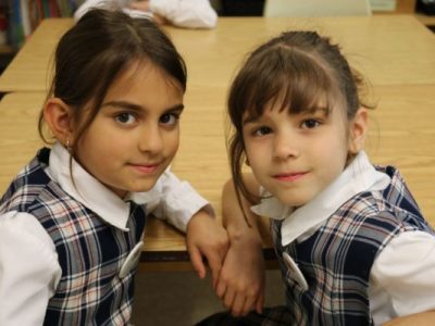 2 girls smiling in a Montessori classroom | Bishop Hamilton Montessori School in Ottawa