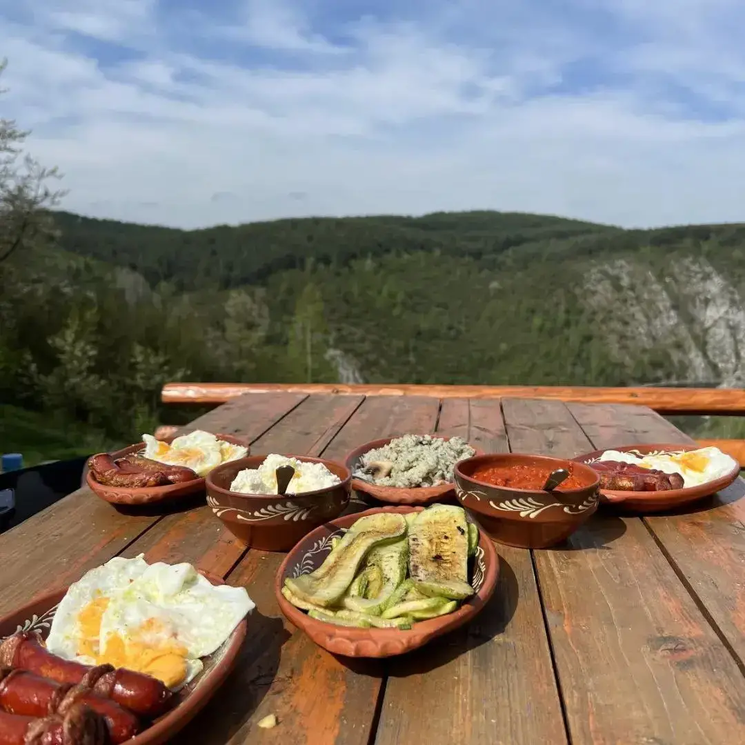 title="Romantična večera na terasi brvnare" alt="tradicionalni doručak sa domaćim sirom i svežim hlebom"