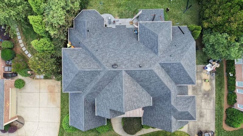 Overhead drone view of a large hip roof with new gray shingles