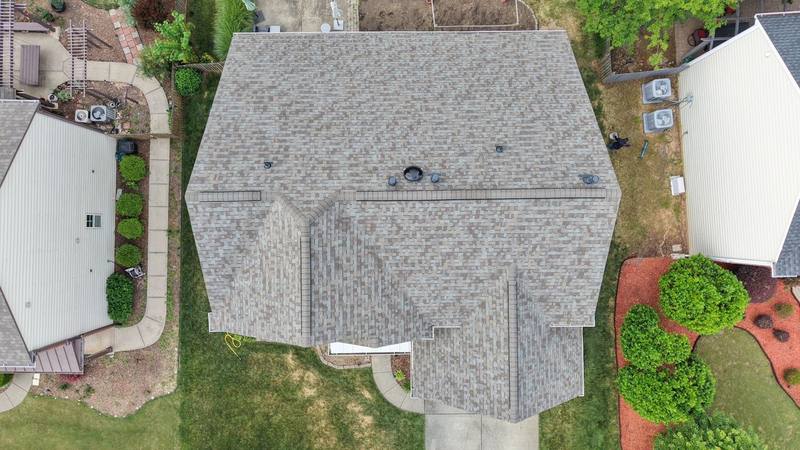 Overhead drone view of a new driftwood-color shingle roof