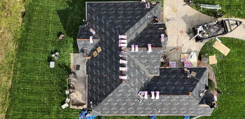 Crew laying new synthetic underlayment before shingles