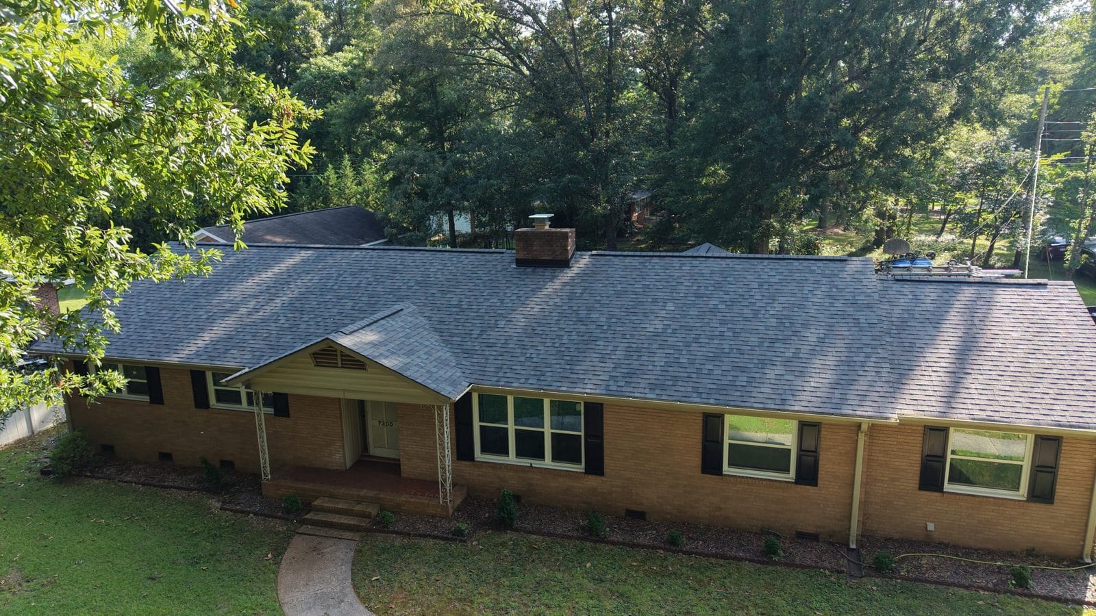 Brick ranch home with a new charcoal shingle roof in Charlotte, NC