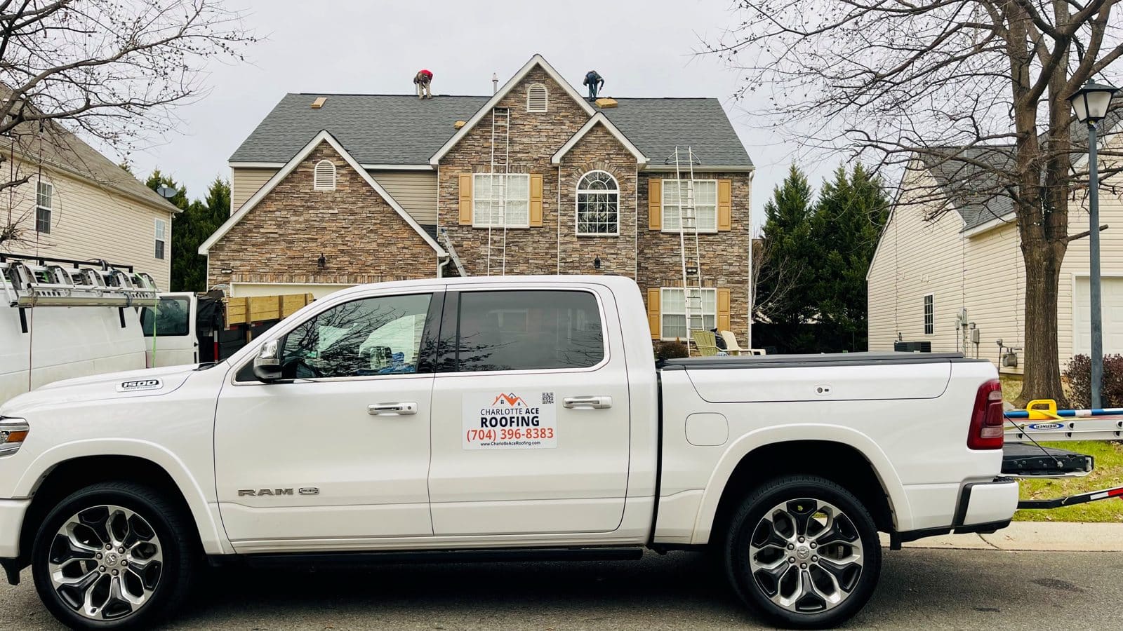 Charlotte Ace Roofing truck and crew working on a stone-front two-story home