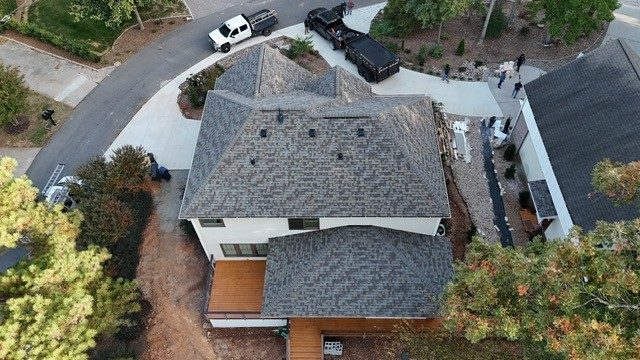 Drone view of a new gray shingle roof on a two-story home in Charlotte, NC