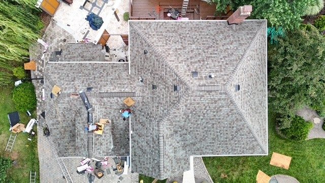 Overhead drone view of a new shingle roof being finished
