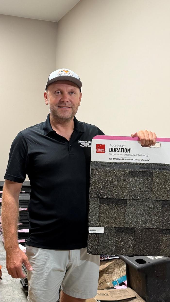 Owner Vasily Zhuk holding an Owens Corning Duration shingle sample