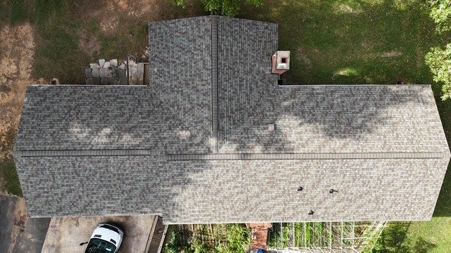 Aerial view of a finished roof replacement with gray architectural shingles in Charlotte, NC