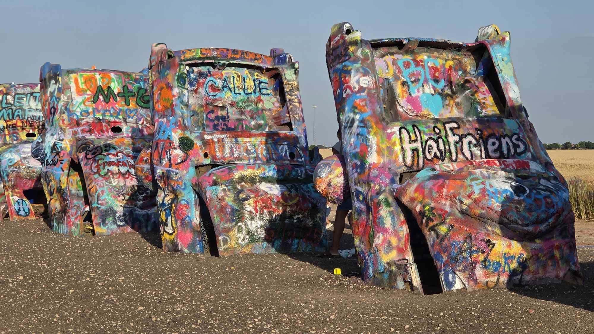 Roadtrip-Stopp an der Cadillac Ranch, bunte Autoreihen im Feld bei Amarillo