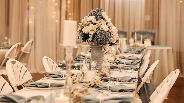 Choctaw Hunting Lodge decorated wedding table with place settings, flowers, and other decor.