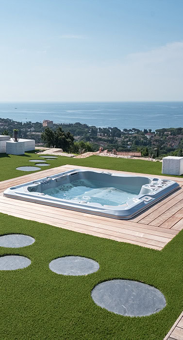 Spa encastré dans une terrasse en bois avec vue sur la mer