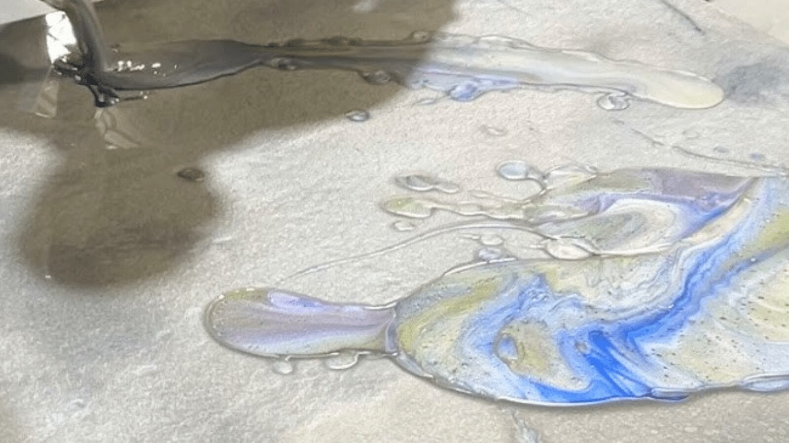A painting of water and bubbles on the ground.