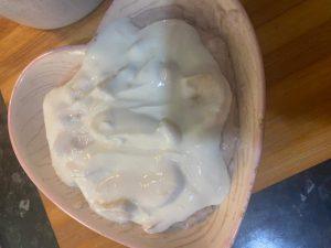 A warm bowl of Chura Gerteh topped with colorful fresh fruits and creamy yogurt