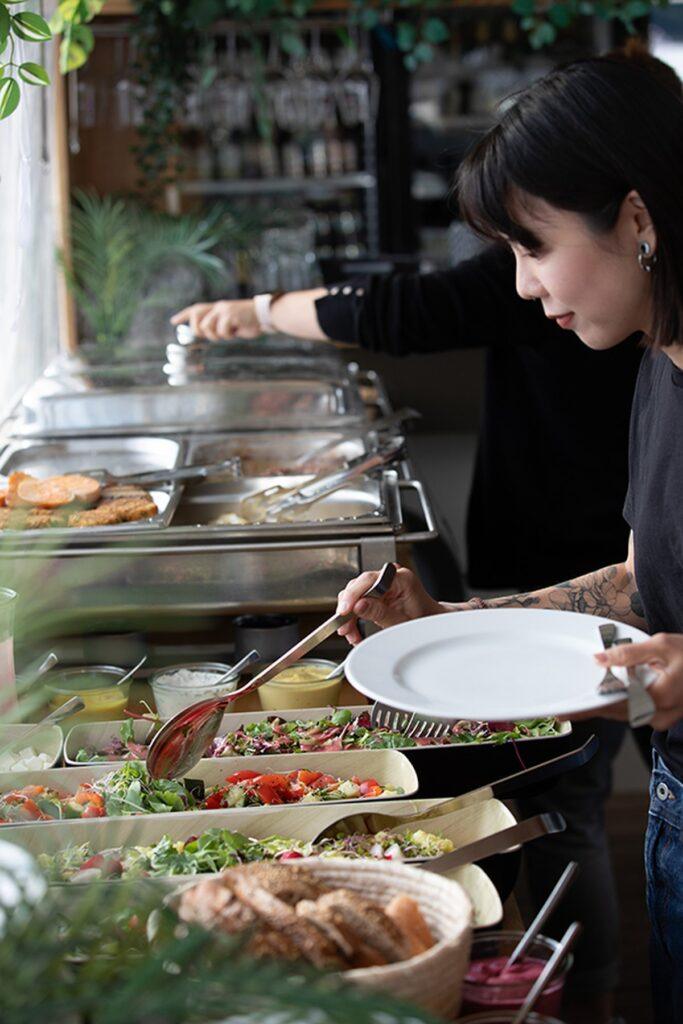 Frau bedient sich am Buffet auf dem Eventfloss