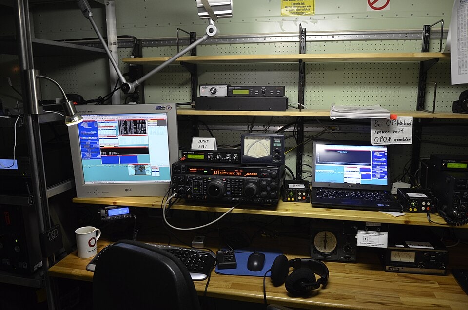 Estación de radioaficionado durante un concurso — transceptores HF, pantallas y equipos de operación