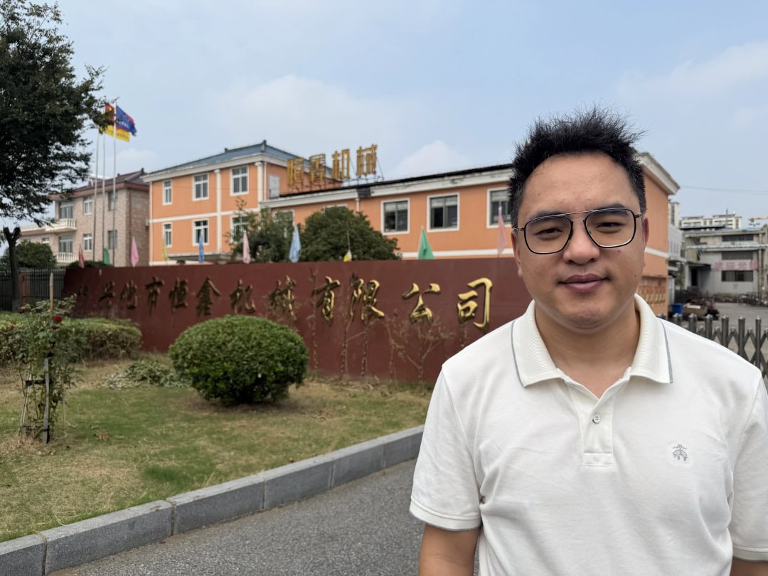 Person beside the factory entrance with the manufacturing building behind
