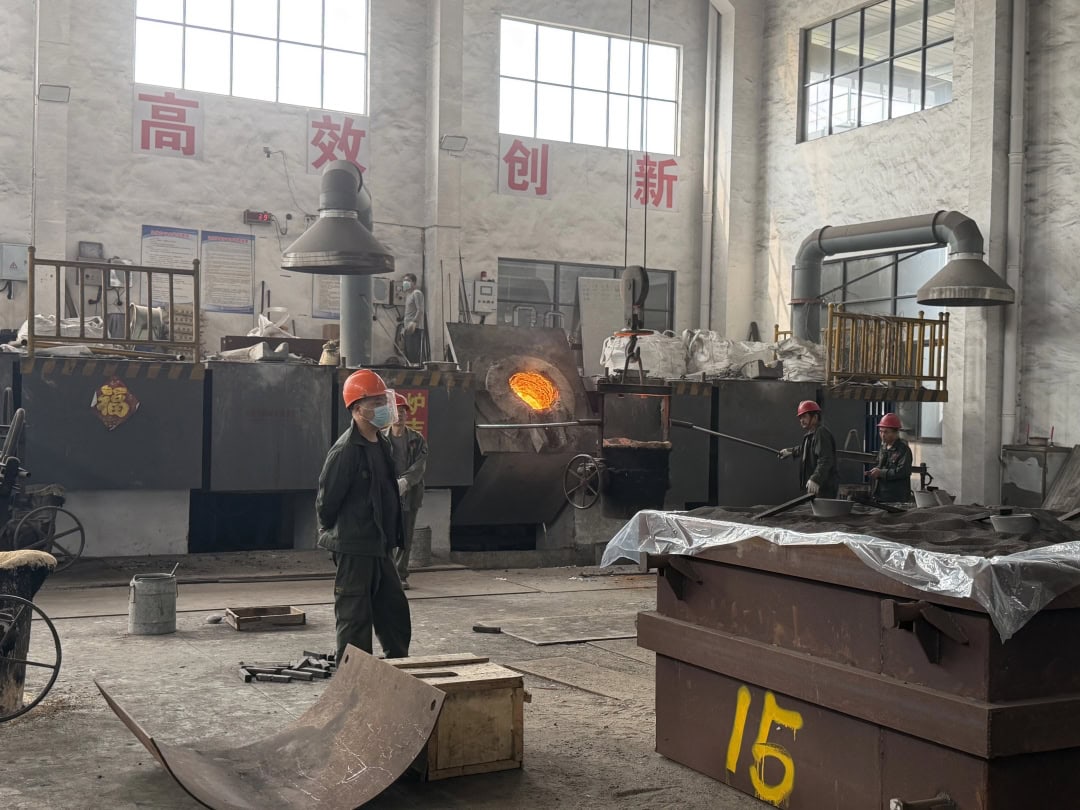 Worker beside an operating furnace in the foundry workshop