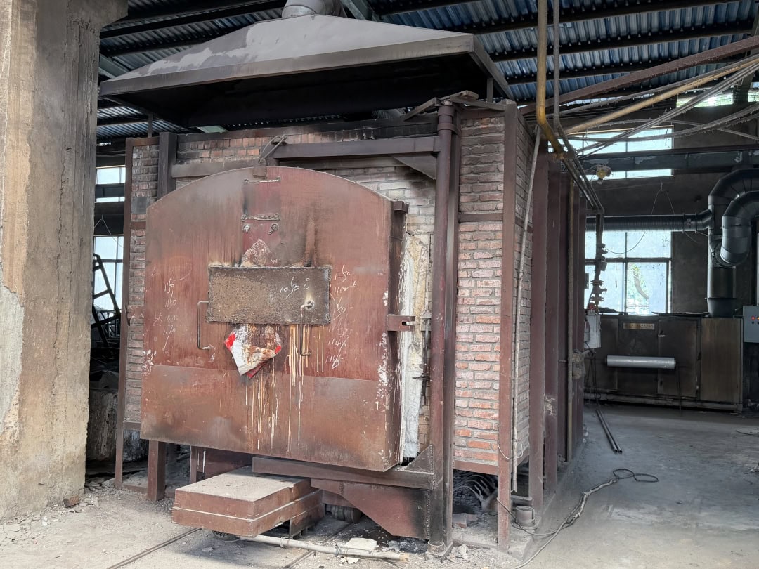 Large industrial furnace with its front door and chamber opening visible in the workshop