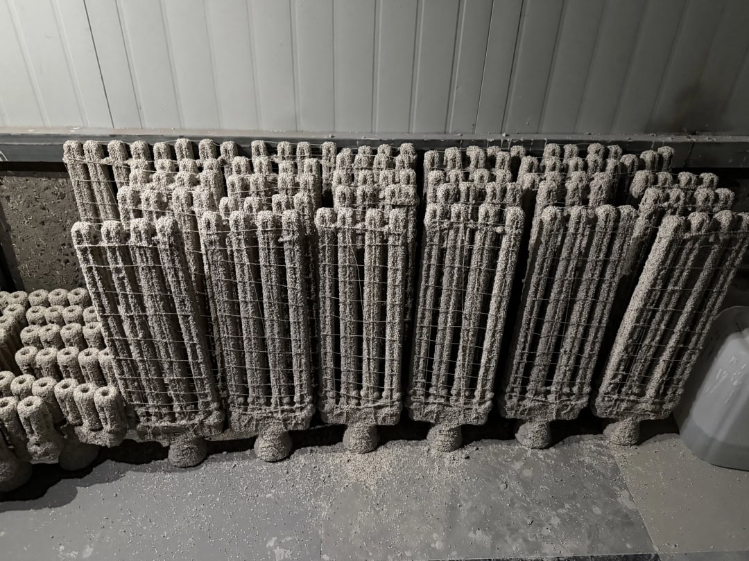 Open-grid furnace castings stacked upright in closely arranged rows