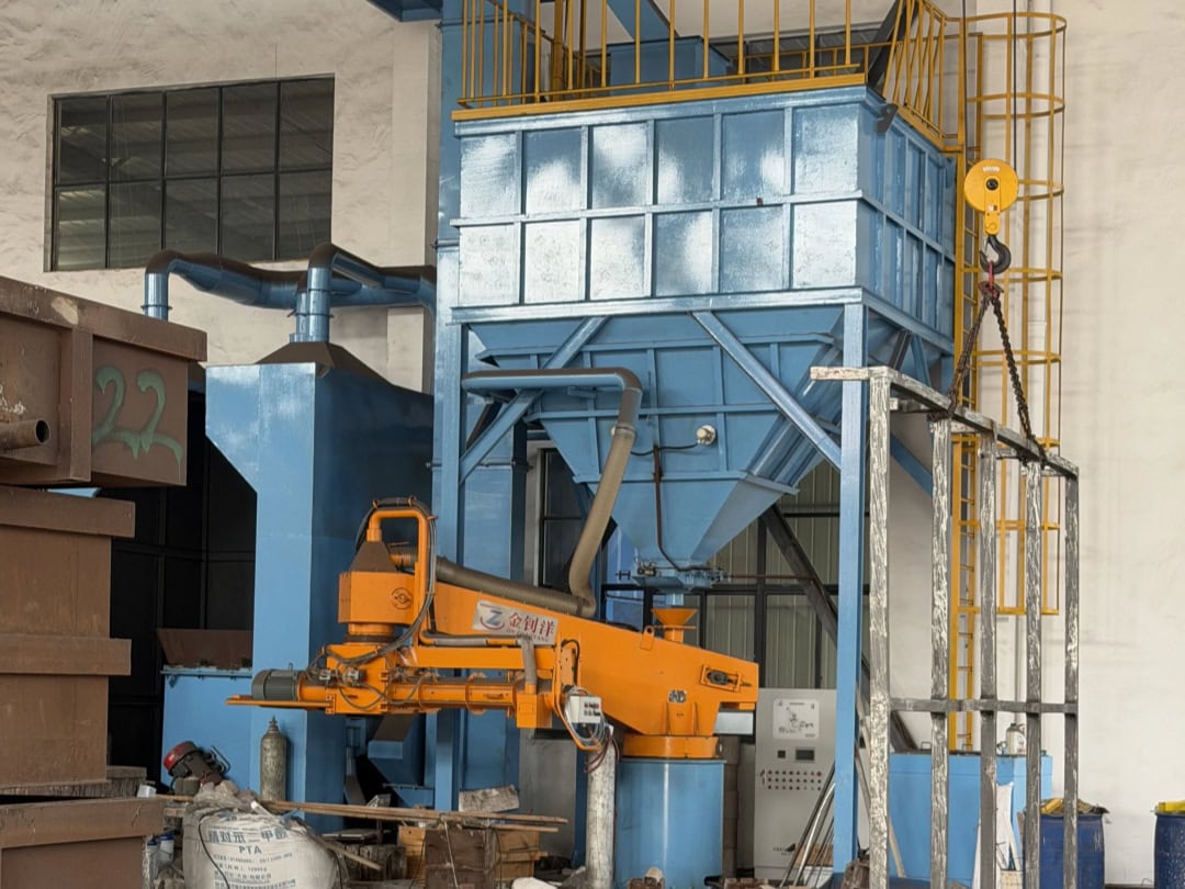 Blue foundry production equipment with a raised steel platform and orange machinery