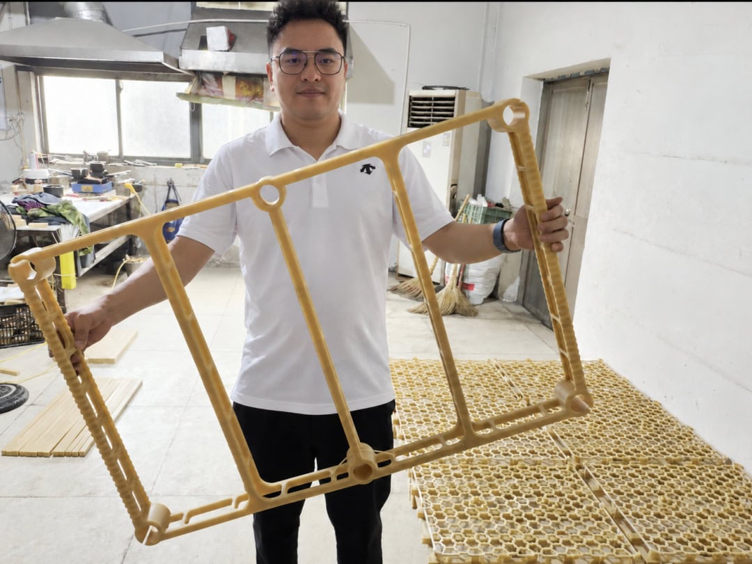 Jonny holding a rectangular furnace fixture wax pattern in the ECOOSUN workshop