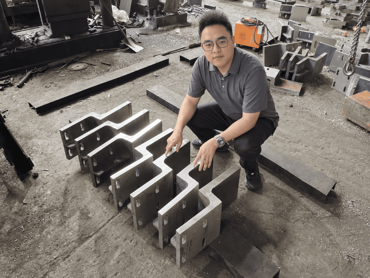Jonny beside large cast furnace components arranged on the ECOOSUN workshop floor