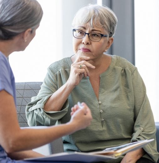 The senior adult woman listens carefully as the unrecognizable female doctor explains the diagnosis to her.