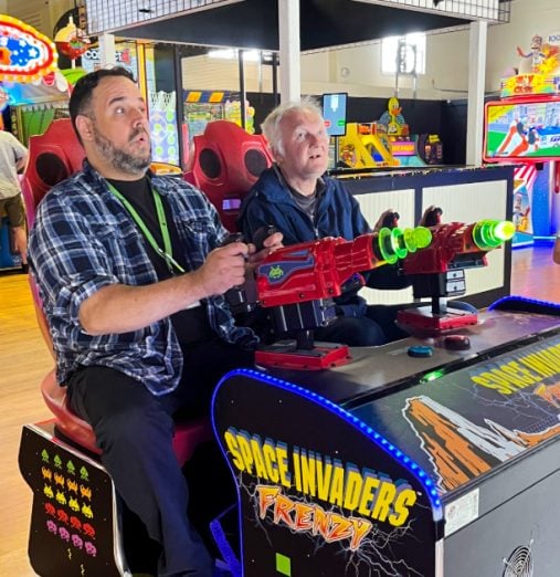 Senior man enjoying arcade games at Element Care PACE day health center while receiving supervised care