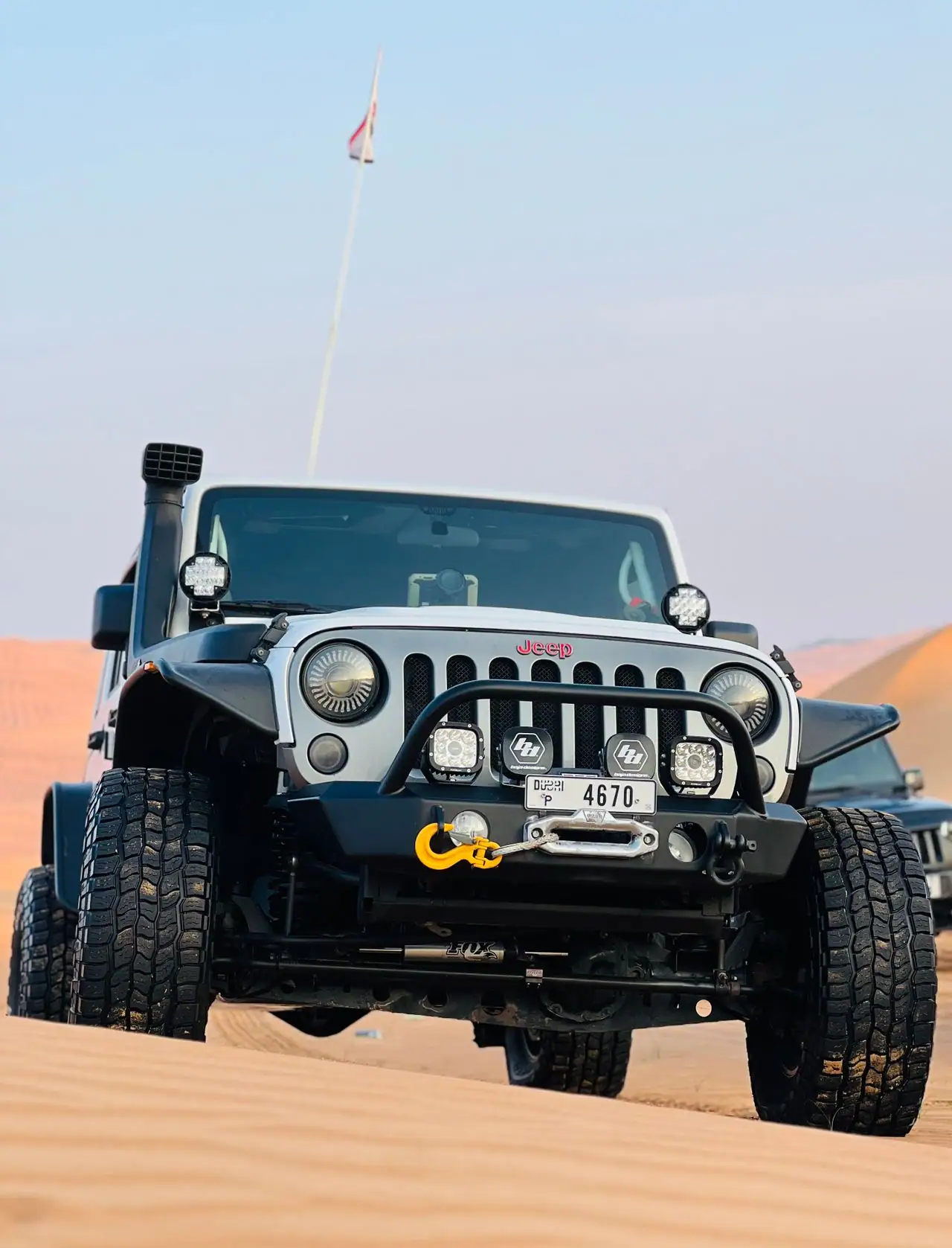 Sandboarding on red dunes during an evening desert safari