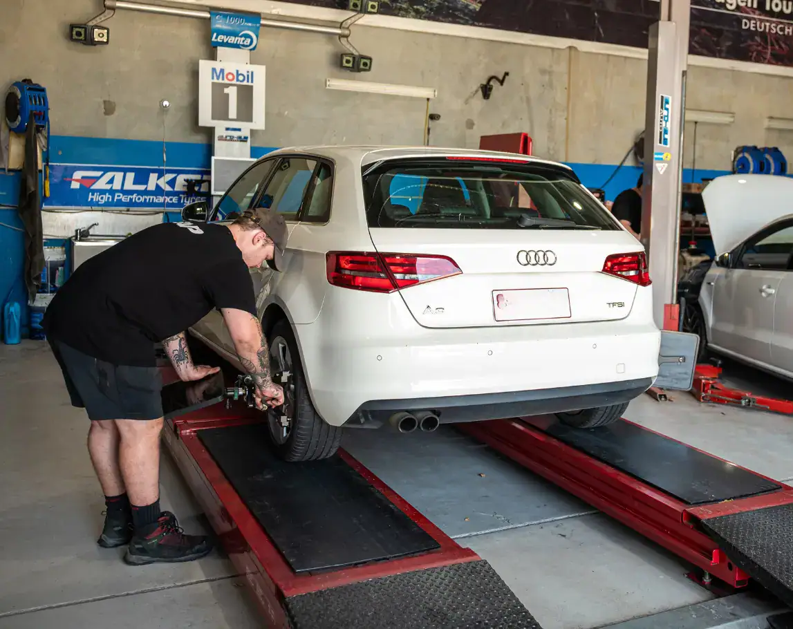 Mechanic working on European car tyres in service bay