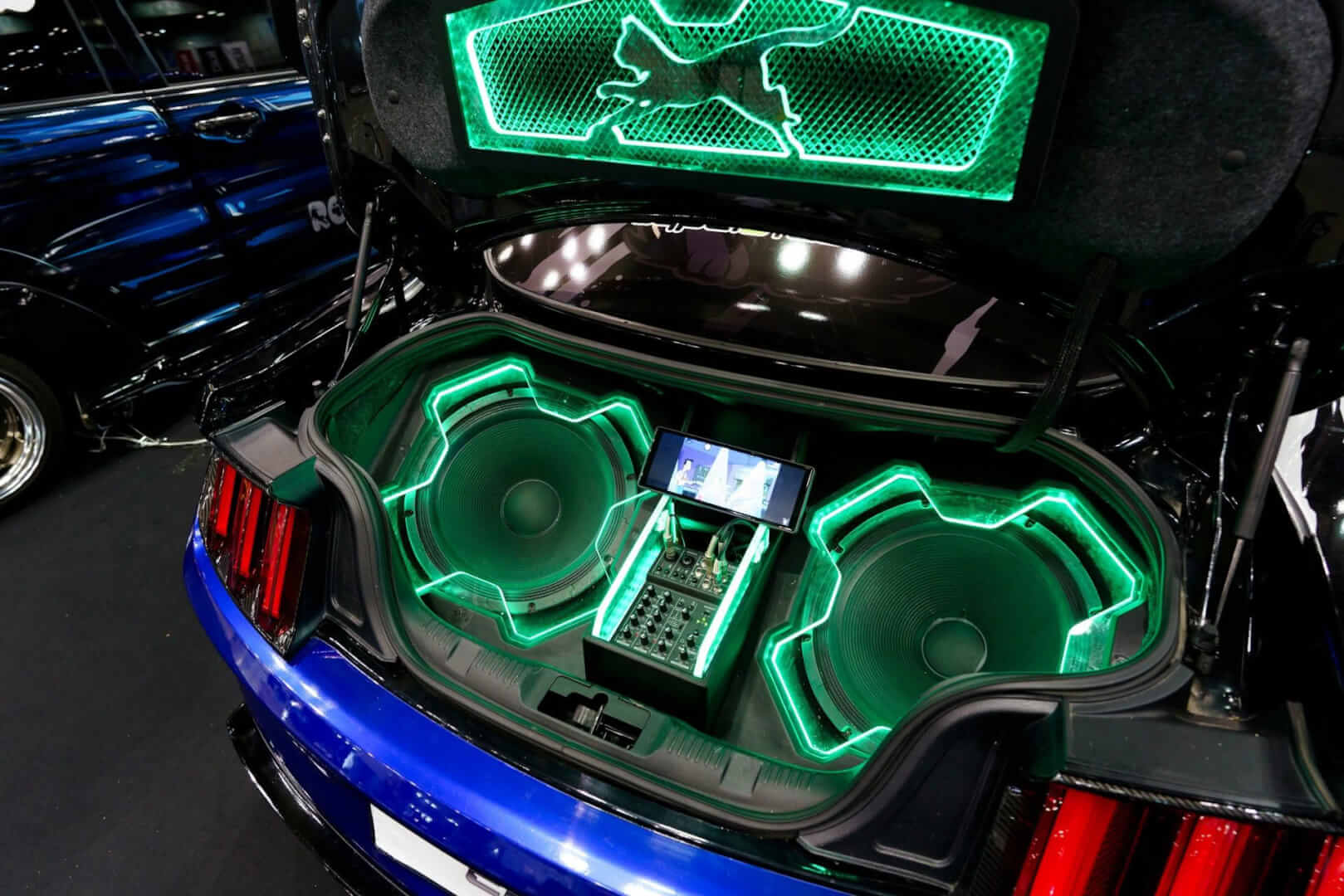 Car trunk with custom audio system and neon lights.