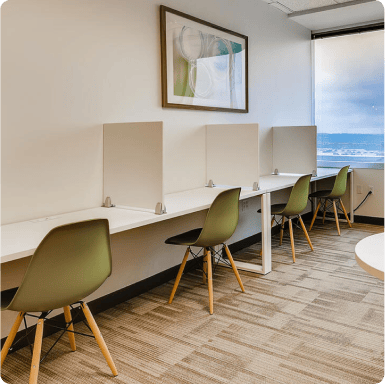 Modern shared workspace with individual desks and green chairs, ideal for office evolution franchising opportunities and growing professional environments.