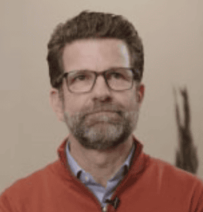 Modern professional man with glasses in a corporate office background, emphasizing Office Evolution franchising opportunities.